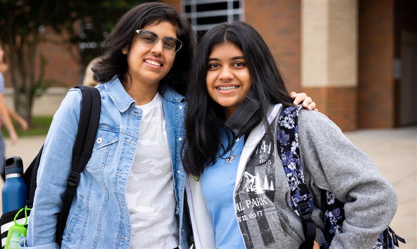 Two students smile
